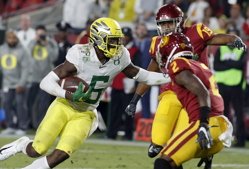 Oregon wide receiver Juwan Johnson cuts towards the end zone for a touchdown against the Trojans in the fourth quarter at the Coliseum on Saturday.

