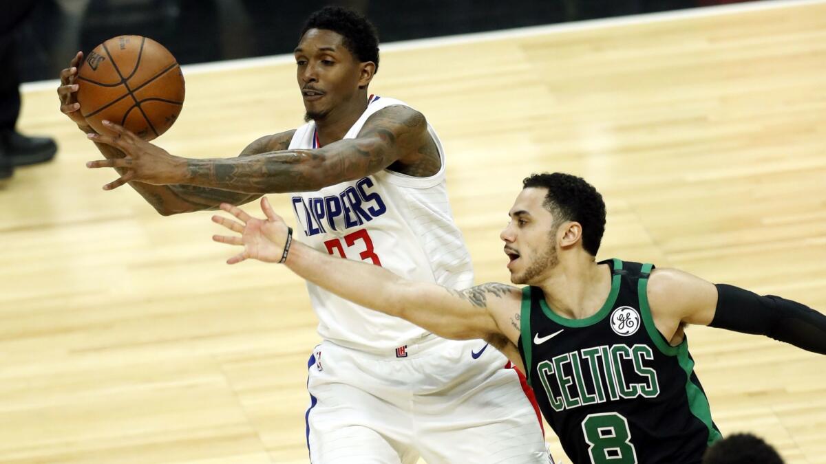 Clippers guard Lou Williams, left, and Boston's Shane Larkin battle for the ball on Jan. 24.