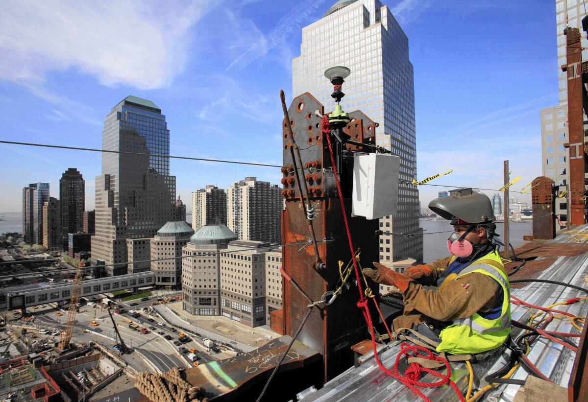 Aecom projects include construction management for the new World Trade Center in New York. Above, a welder works on the project.