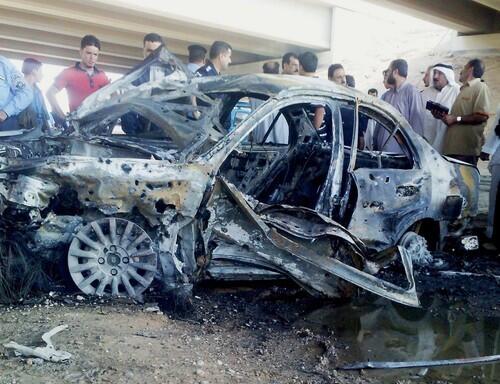 Iraqis gather around a car destroyed in a suicide attack at a security checkpoint in Ramadi, west of Baghdad. Eight people were killed, Anbar provincial police said. Attacks elsewhere killed nine people.