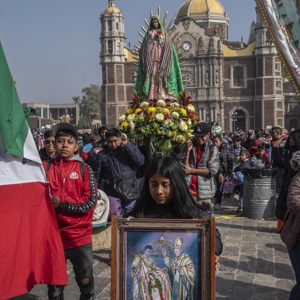 People carrying a clay figure of the Virgin walk out from the Basilica of Guadalupe