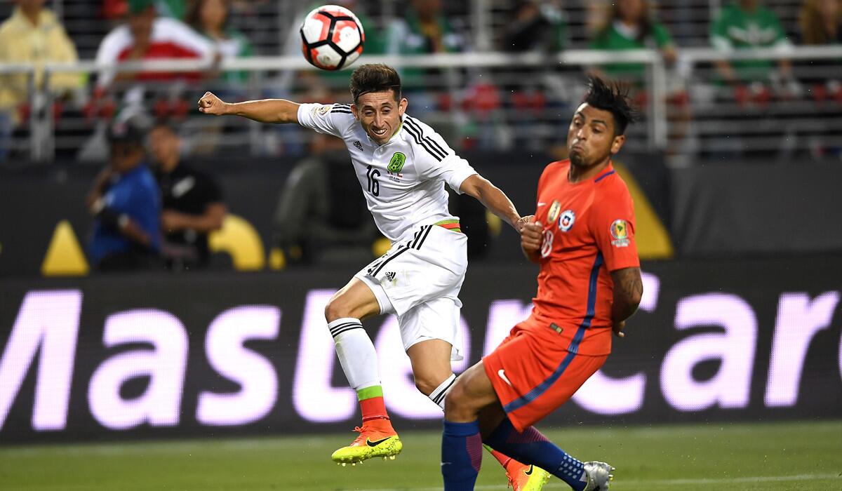 Mexico's Hector Herrera, left, shoots on goal past Chile's Arturo Vidal during the 2016 Copa America Centenario quarterfinals on Saturday.