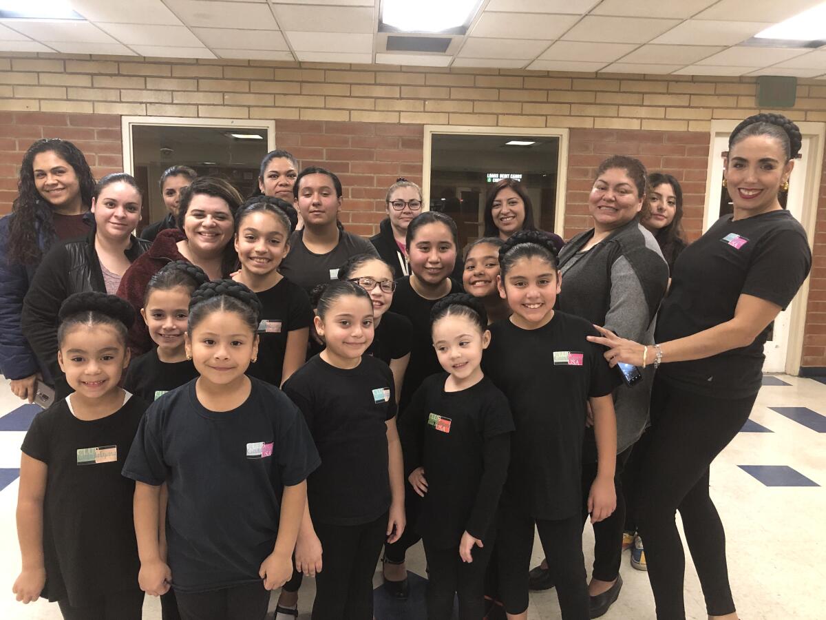 Madres de familia y alumnas del ballet folclórico posan para la fotografía después de una práctica regular.