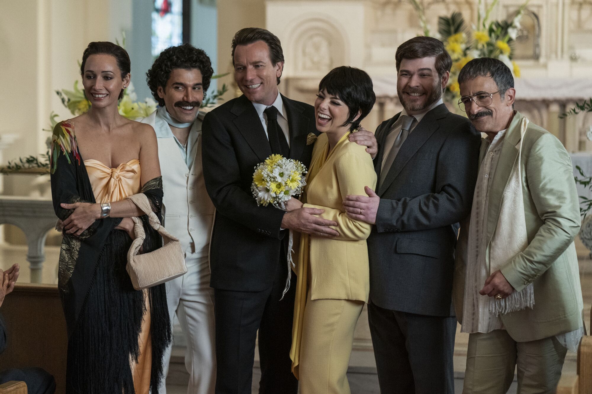 A scene from "Halston" shows Liza Minnelli and her wedding party smiling and laughing in the 1970s.
