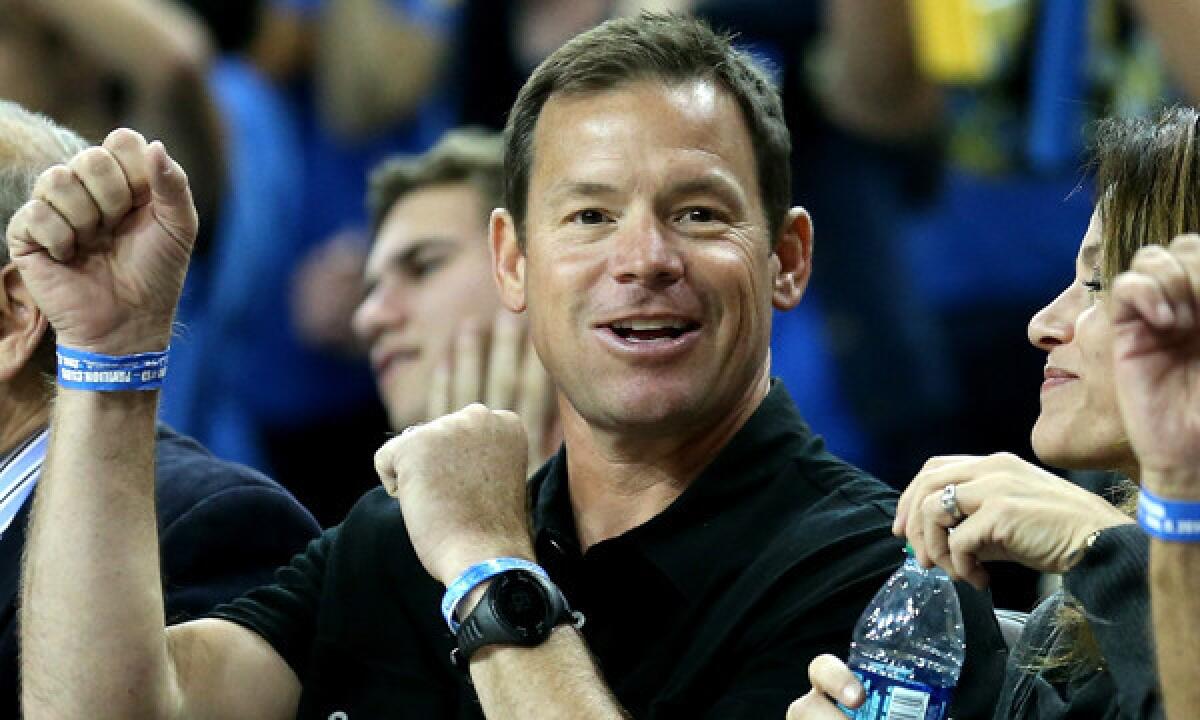 UCLA football Coach Jim Mora cheers during a UCLA-Arizona men's basketball game on Jan. 9. Mora's contract with the university stipulates the school must begin construction on a new football practice facility by October 2015.