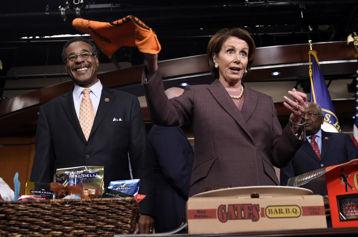 House Minority Leader Nancy Pelosi twirls a San Francisco Giants baseball rally towel as Rep. Emanuel Cleaver II (D-Mo.) watches after they pay off a World Series bet on Nov. 18.