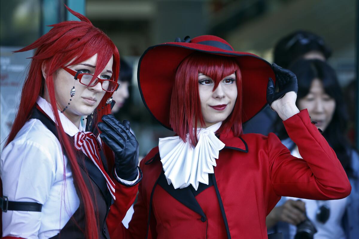 Mikaylee Collins, left, dressed up as Grell Sutcliff and Jenny Joboyan dressed up as Angelina Dallas, both characters from the anime series "Black Butler."