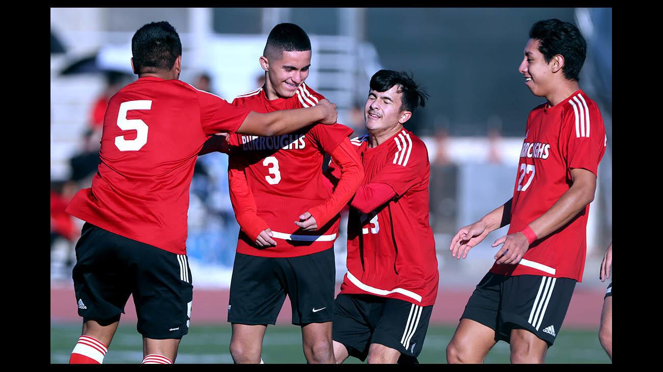Burroughs High School soccer player #3 Manny Gonzalez is mobbed by teammates after he scored an early goal in the first half of the Crescenta Valley Winter Classic final game vs. Birmingham High School (Lake Balboa), at Crescenta Valley High School in La Crescenta on Saturday, Dec. 29, 2018. Birmingham won 5-4 on penalty kicks after a 1-1 tie at end of regulation.