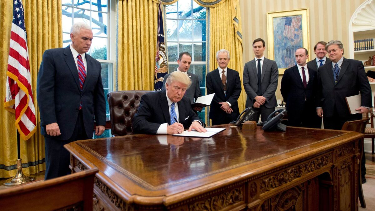 President Trump signs an executive order banning federal funding of abortions overseas in the Oval Office on January 23.
