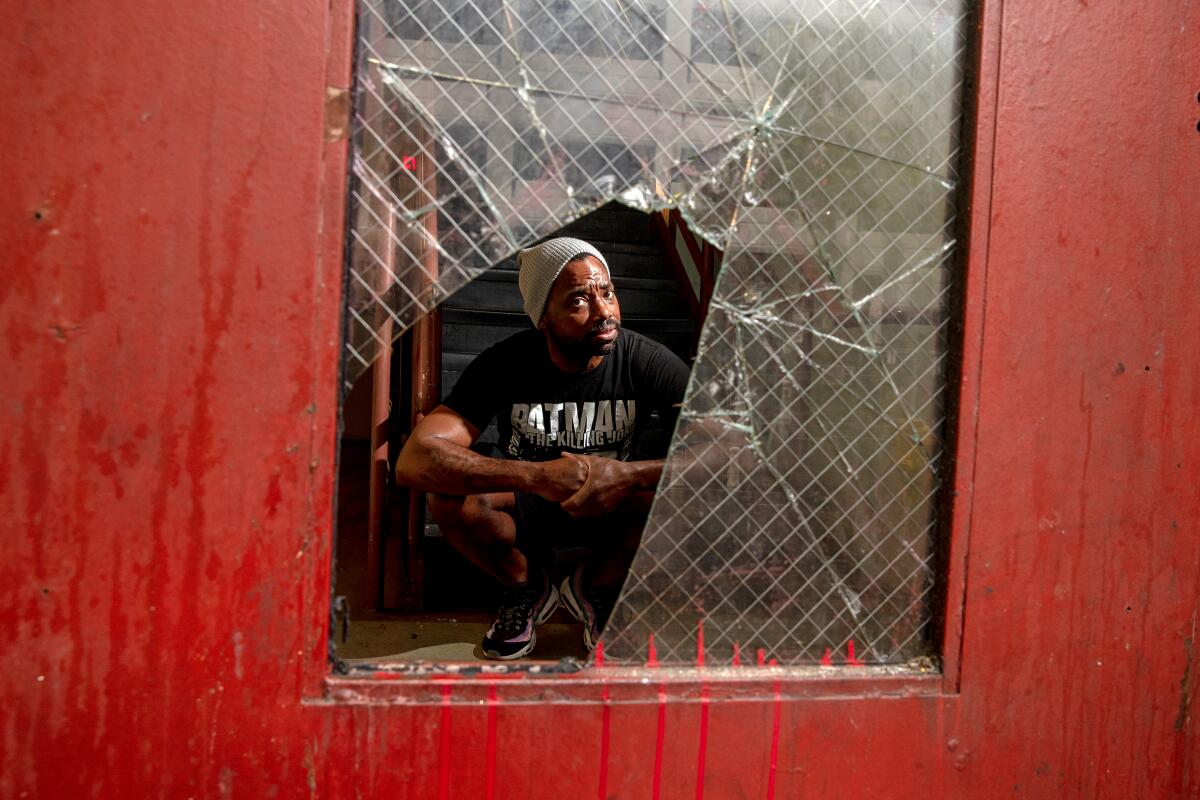 A five-year resident of the Sanborn Hotel Apartments looks through broken glass. 