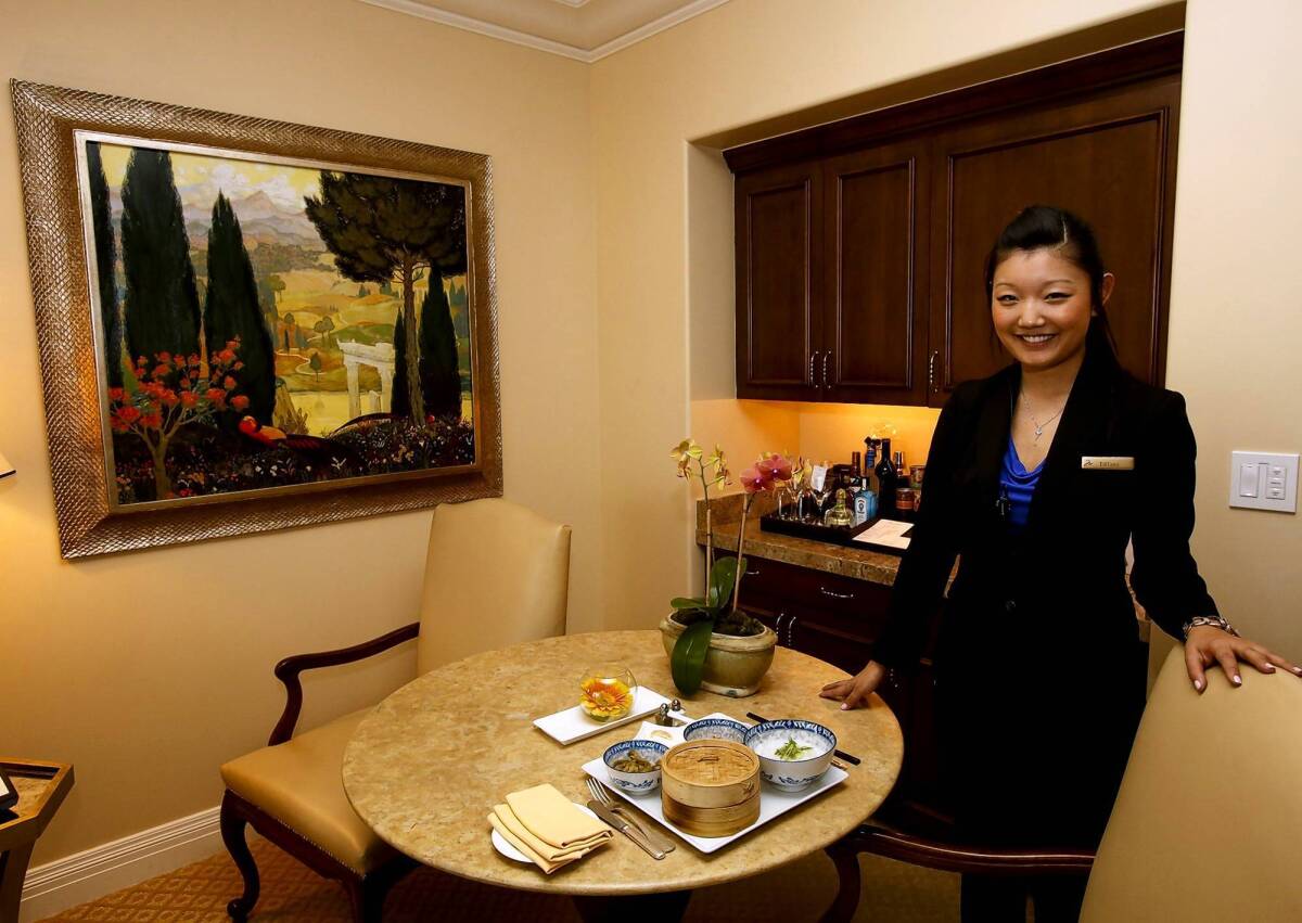Tiffany Li, a guest relations agent at the Montage Beverly Hills, displays a traditional Chinese breakfast in one of the suites. The hotel is adding services and extras to draw Chinese tourists.