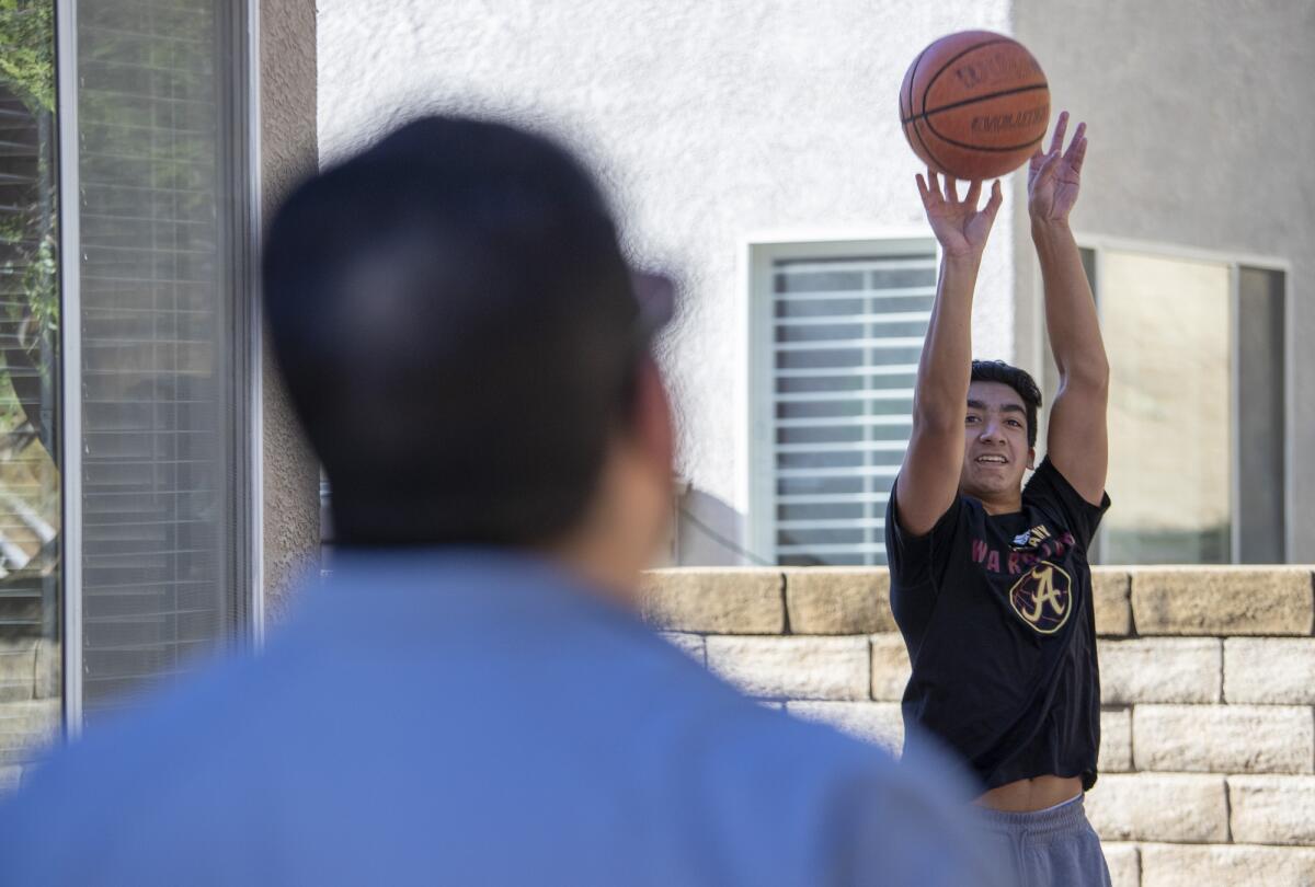 Bishop Alemany High guard Nico Ponce, right, works out on his backyard court with father Manuel at their home in Castaic.