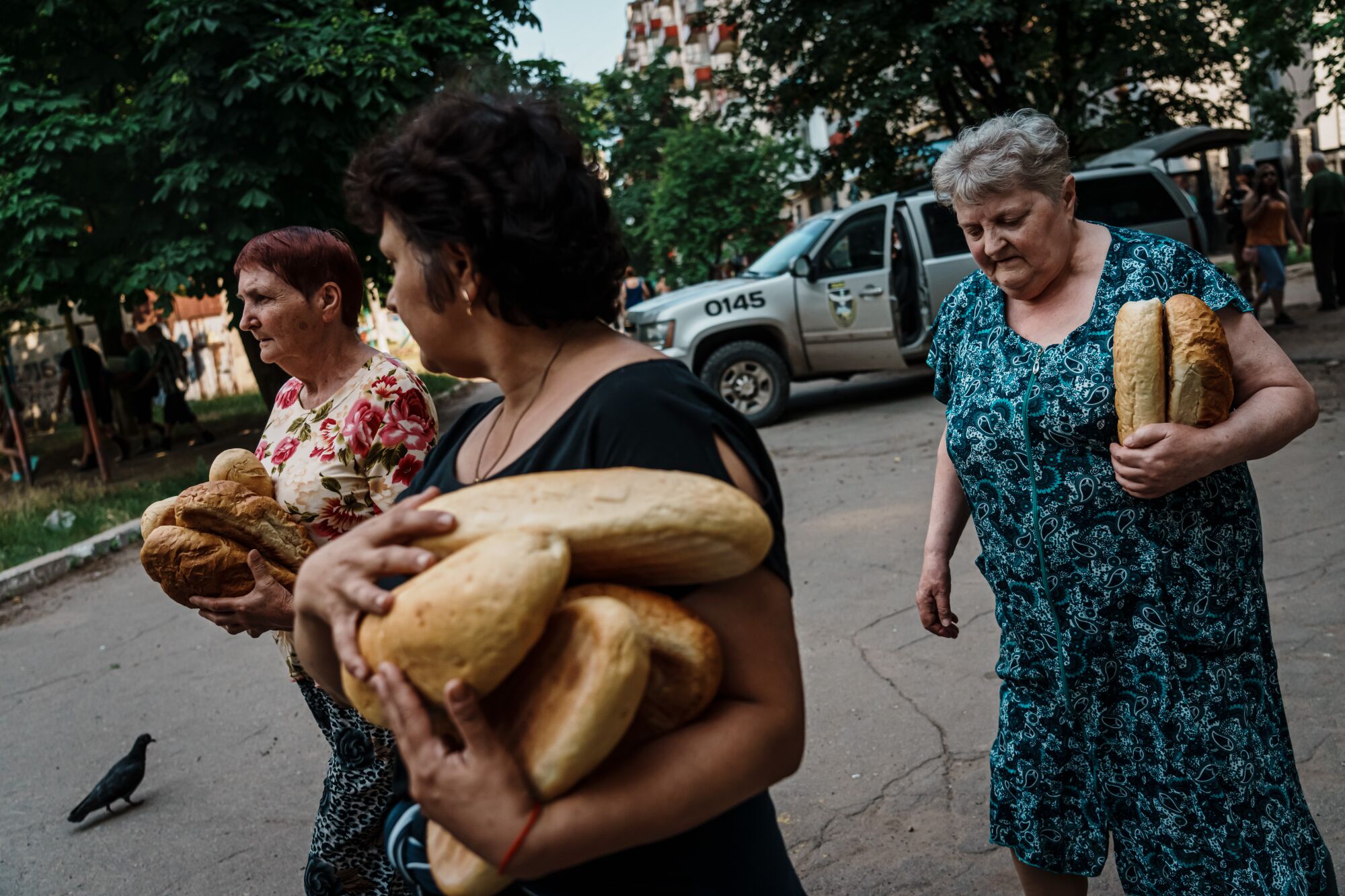 Residents carry food given to them by police officers in Lysychansk, Ukraine.