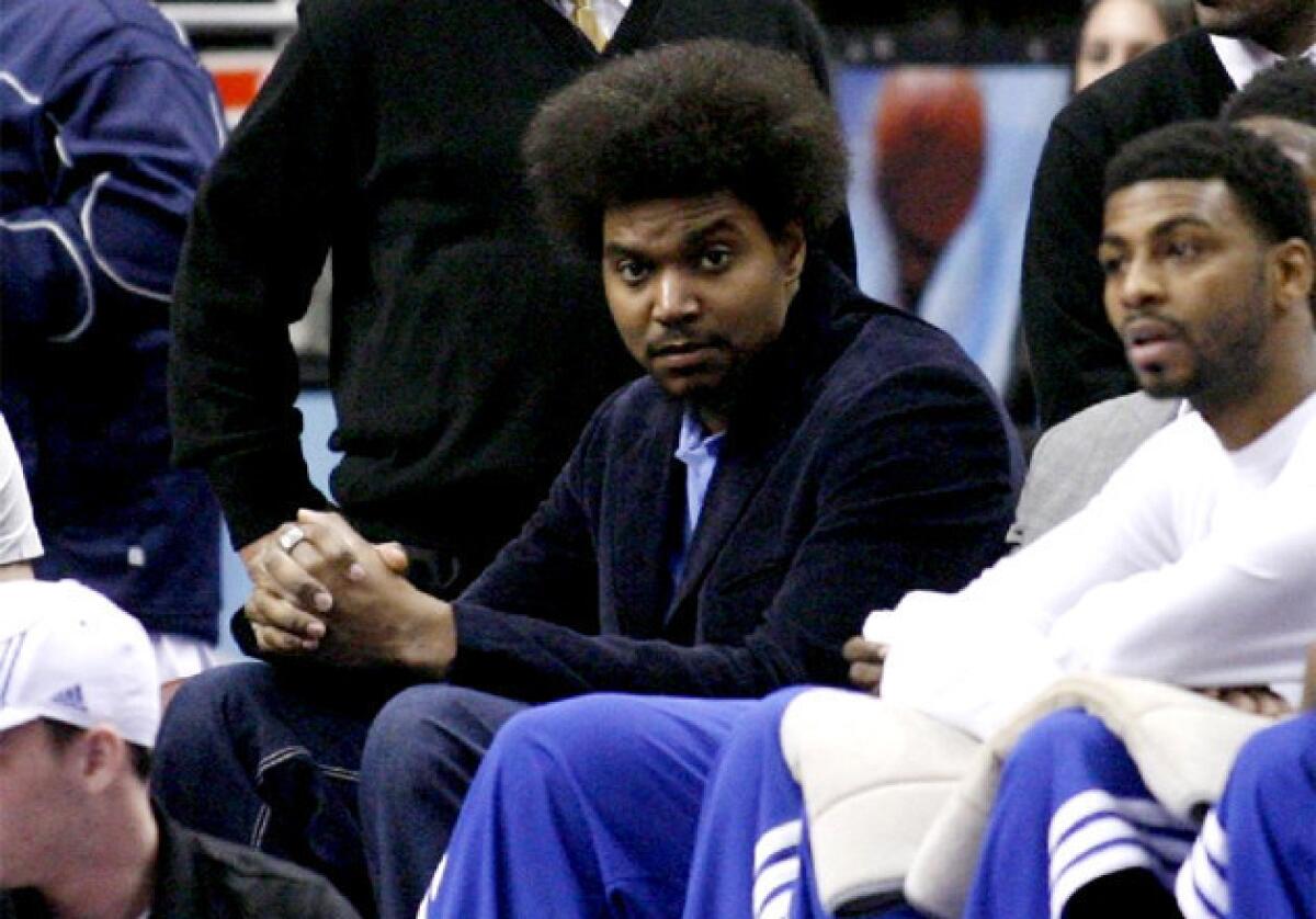 Sixers center Andrew Bynum sits on the bench as his team plays against the Golden State Warriors.
