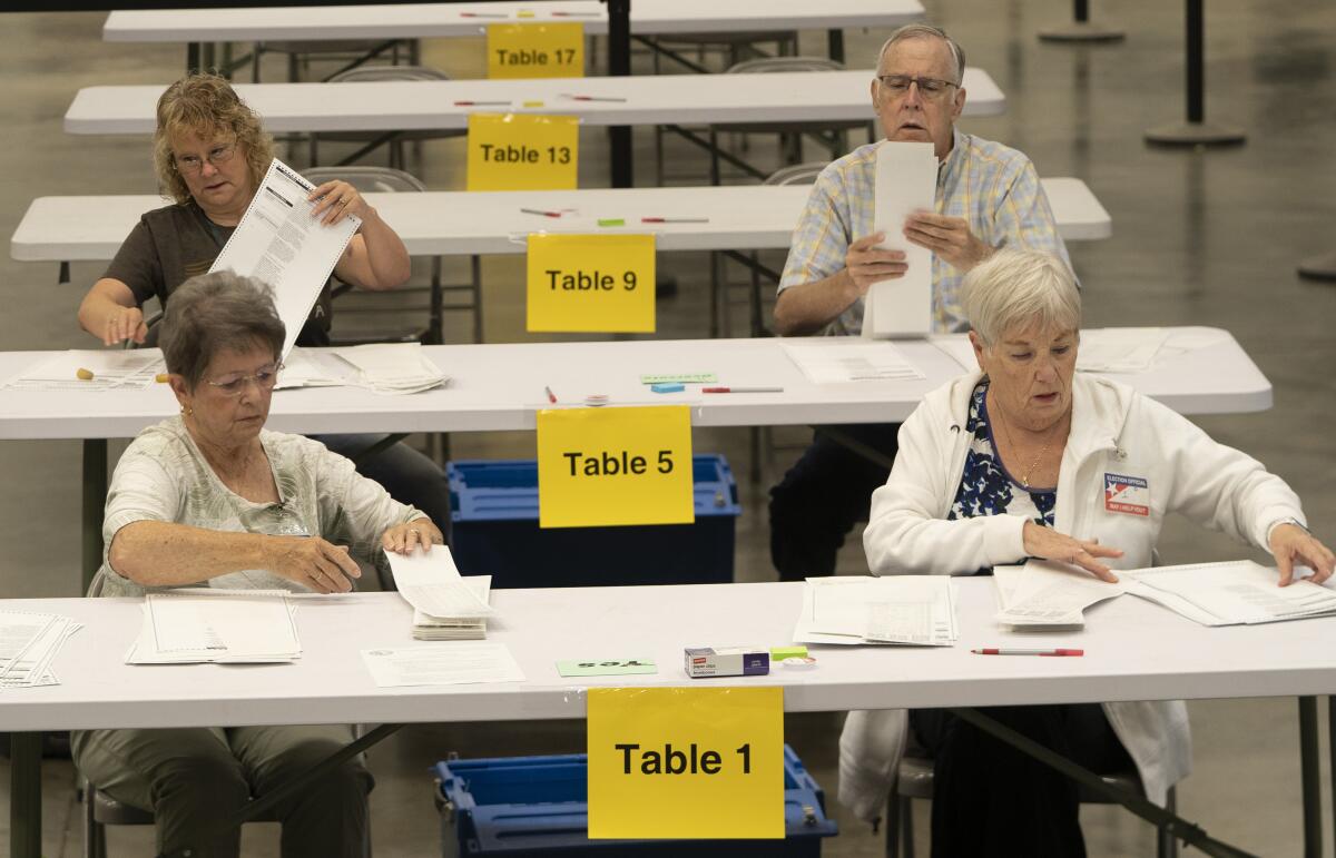 Vote tabulators working at tables