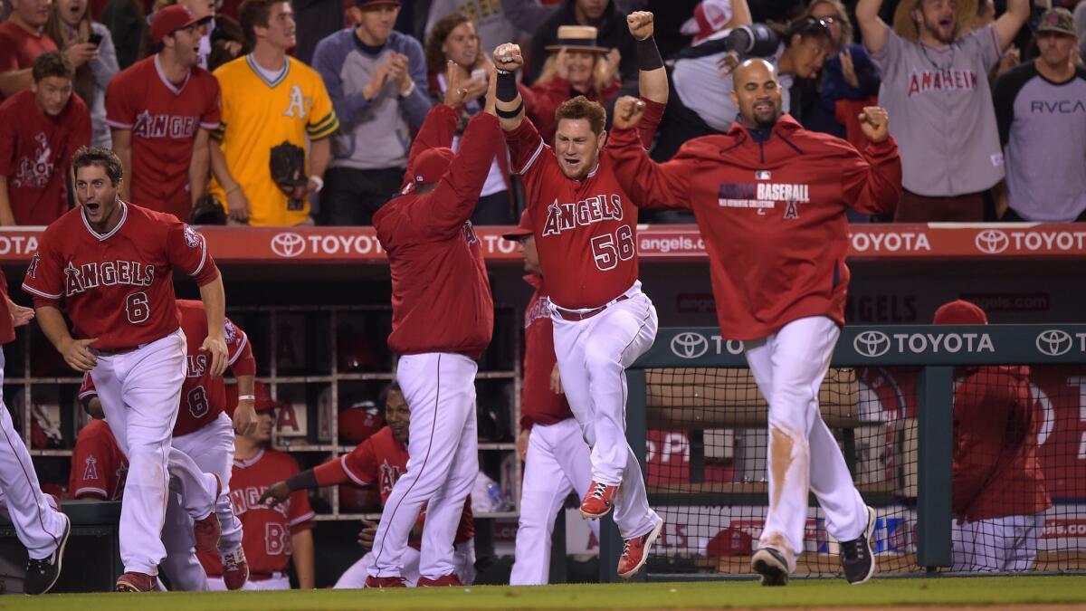 Angels players celebrate Collin Cowgill's winning home run in the 14th inning of the team's 2-1 victory over the Oakland Athletics on Tuesday.