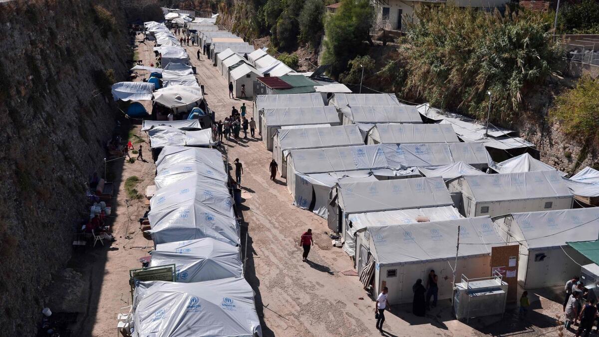 People make their way in the Souda migrant camp in Chios, Greece, in September 2016. Unknown assailants attacked the camp in November, officials said.