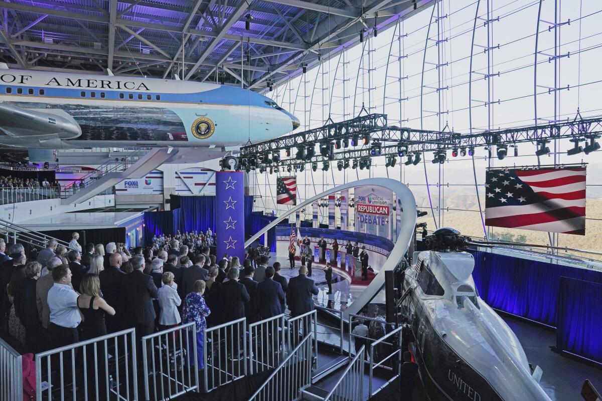 People on a stage at the Ronald Reagan Presidential Library in Simi Valley, with Air Force One looming overhead