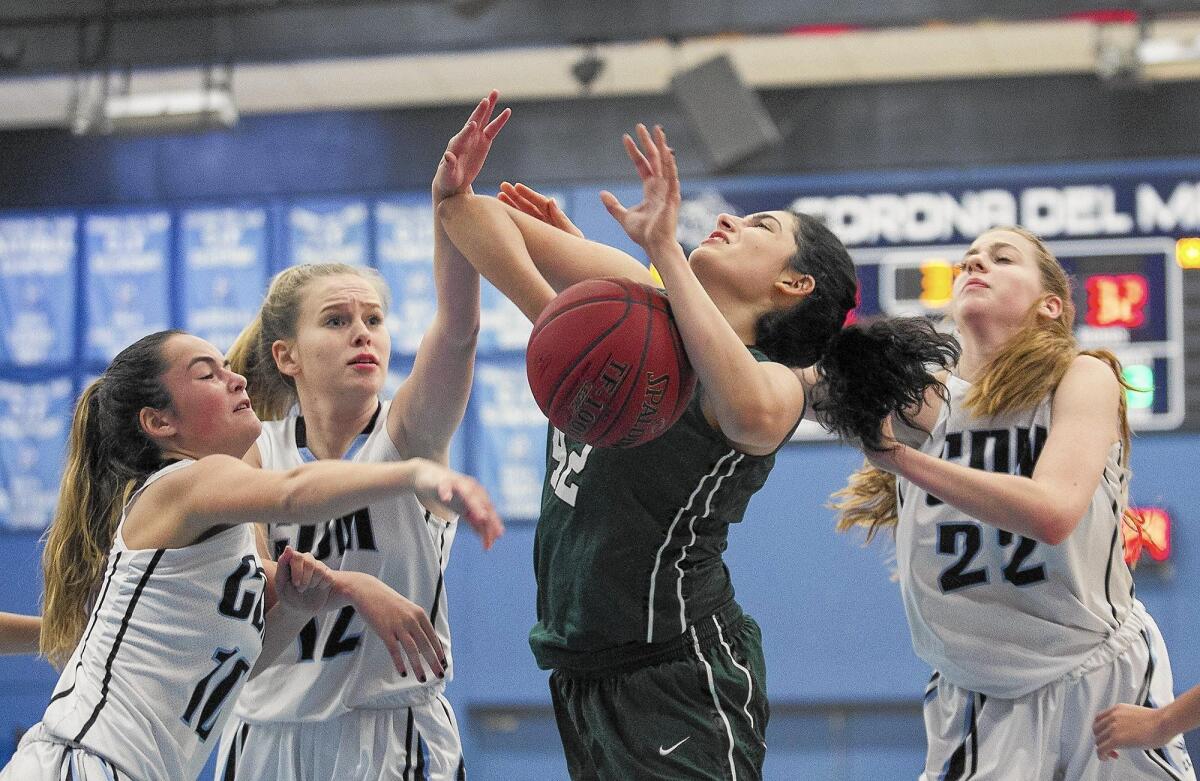 Sage Hill School’s Nadia Akbari goes up for a shot while being triple teamed by Corona del Mar High’s Tia Grippo, left, Sophie Beador and Tatiana Bruening during a game in the Tip-Off Tournament on Wednesday.