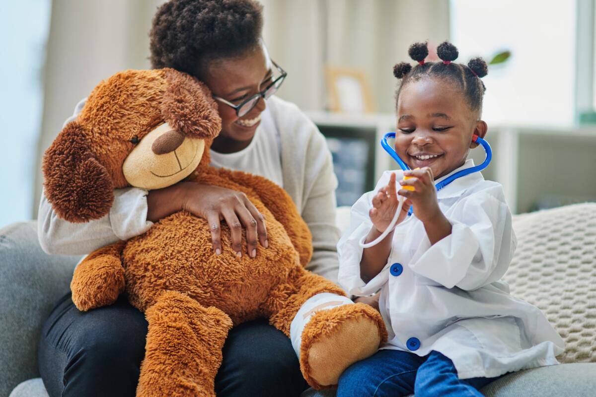 Shot of an adorable little girl and her mother playing with a stethoscope in the waiting room of a doctor’s office