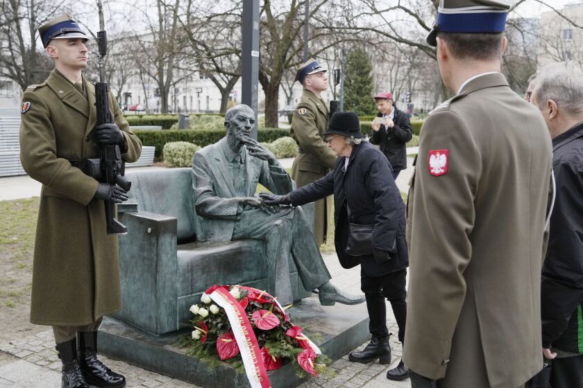 Members of a foundation supporting Poles who saved Jews from the Holocaust honour resistance emissary Jan Karski, who informed western leaders about mass killings of Jews by Nazi Germans, during national day of remembrance of Poles who risked their lives to save Jews, in Warsaw, Poland, on Friday, March 24, 2023. The solemn meetings, wreath laying and prayers Friday were held 79 years after the entire Ulma family were shot dead along with eight Jews whom their were hiding in their farm. (AP Photo/Czarek Sokolowski)