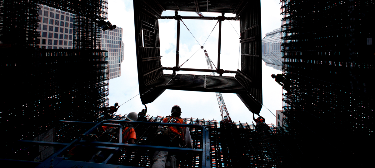 Construction workers guide a jumping wall form system into place as it is lowered into position by a crane into the core of the 73 story, 1100 foot tall Wilshire Grand Tower in Downtown Los Angeles that will be the tallest structure west of the Mississippi River, its developers say, when its 160 foot spire is included.