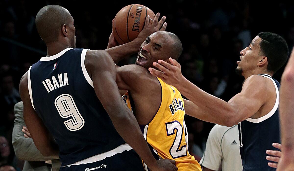 Lakers guard Kobe Bryant is under pressure from Thunder forward Serge Ibaka (9) and guard Anthony Morrow in the first half.