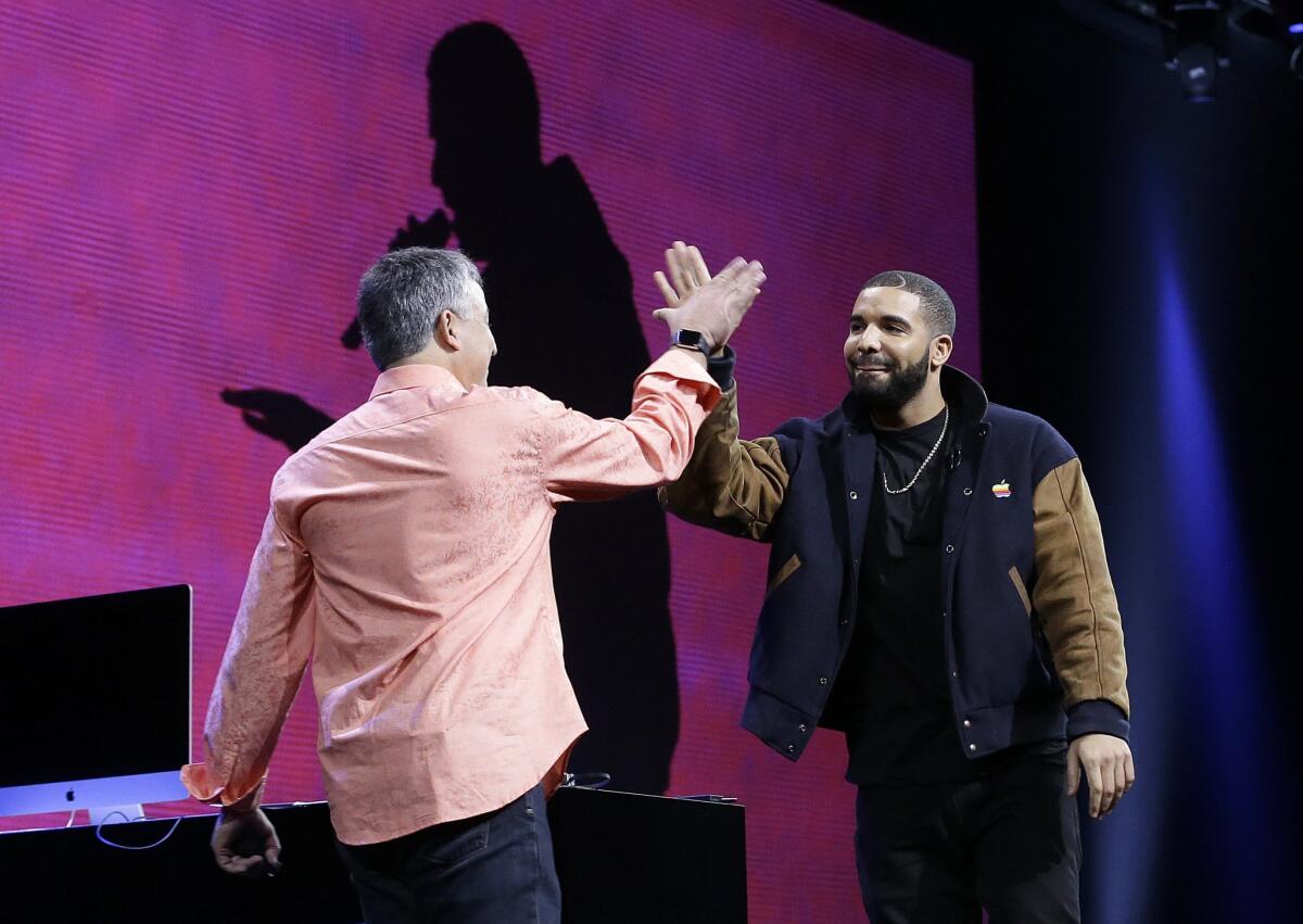Musician Drake, right, high fives Eddy Cue, Apple senior vice president of Internet Software and Services, during the Apple Worldwide Developers Conference in San Francisco