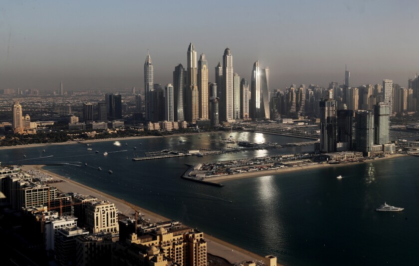 Luxury towers dominate the skyline in the Marina district, center, and the new Dubai Harbour development, right, are seen from the observation deck of "The View at The Palm Jumeirah" in Dubai, United Arab Emirates, Tuesday, April 6, 2021. Foreign buyers flush with cash have flooded the high-end property market in Dubai even as coronavirus vaccines roll out unevenly across the world and waves of infections force countries to extend restrictions. It's one of the few places in the world where they can dine, shop and do business in person. (AP Photo/Kamran Jebreili)