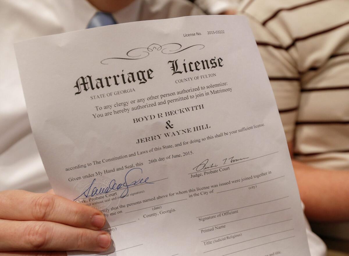 Boyd Beckwith holds his marriage license with his soon-to-be spouse Jerry Hill during a mass wedding ceremony in Atlanta on Friday.