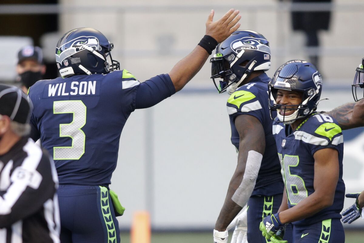 Seattle Seahawks quarterback Russell Wilson (3) celebrates with wide receiver DK Metcalf, center, after Wilson passed to Metcalf for a touchdown against the San Francisco 49ers during the first half of an NFL football game, Sunday, Nov. 1, 2020, in Seattle. (AP Photo/Scott Eklund)