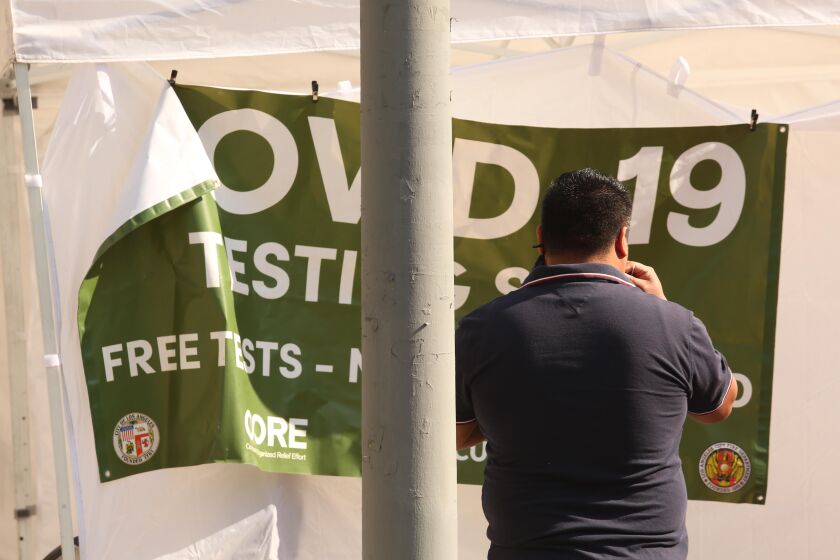 LOS ANGELES, CA - NOVEMBER 25, 2020 - A man performs an oral test for COVID19 at a free testing site along Sunset Blvd. in Echo Park on November 25, 2020. (Genaro Molina / Los Angeles Times)