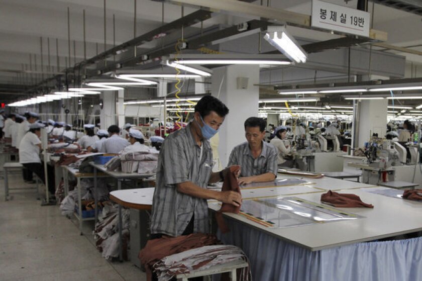 In this file photo, two North Koreans working for ShinWon, a South Korean clothing maker, prepare garments for production at a factory in Kaesong, North Korea.