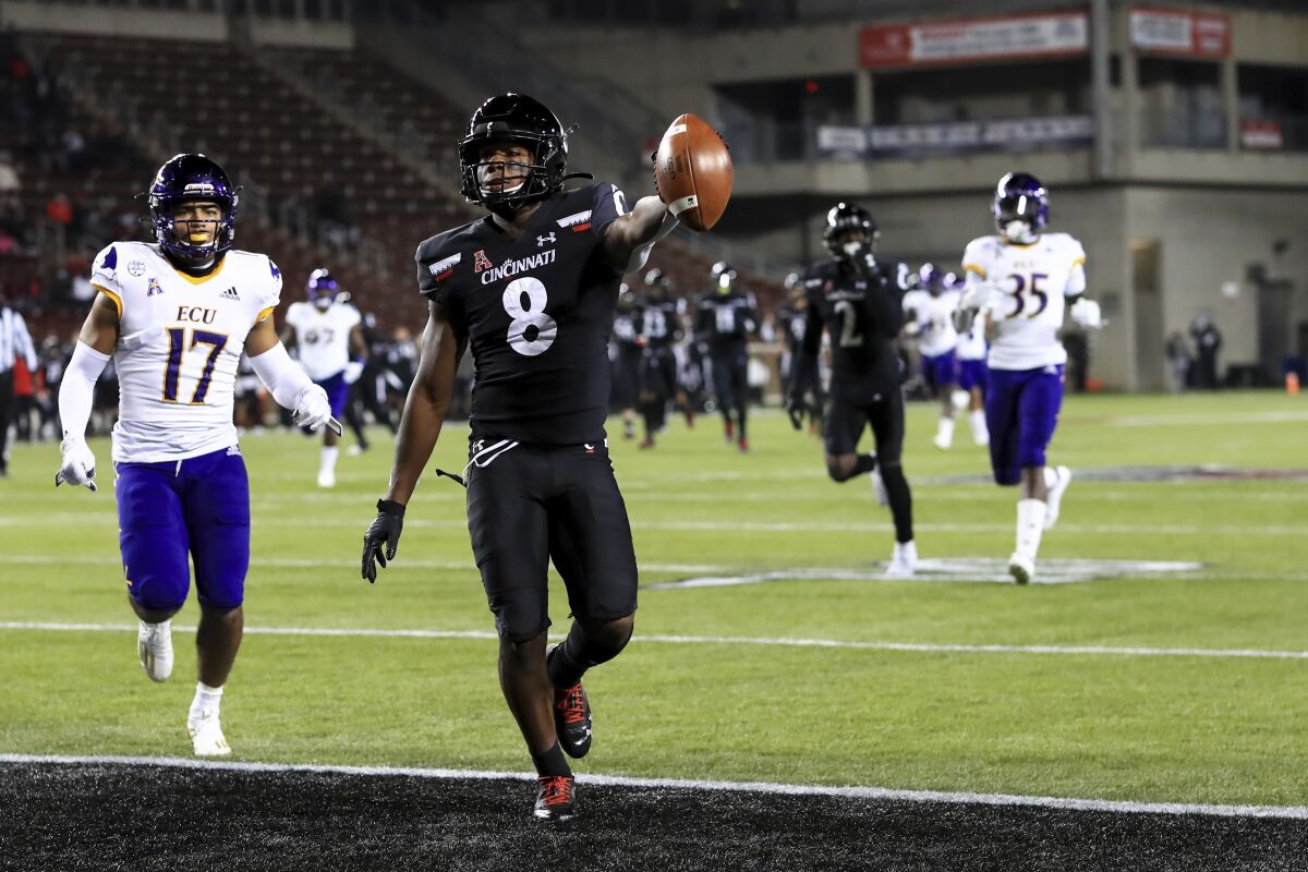 Cincinnati wide receiver Michael Young Jr. holds the ball up as he scores a touchdown during the first half of the team's NCAA college football game against East Carolina, Friday, Nov. 13, 2020, in Cincinnati. (AP Photo/Aaron Doster)