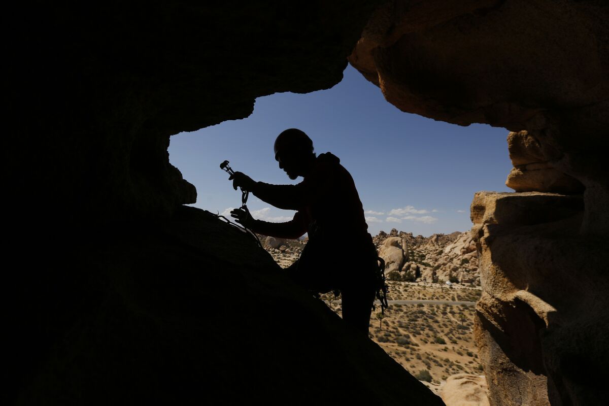 Seth Zaharias, 39, who runs Cliffhanger Guides with his wife Sabra Purdy, 37, cleans a camming device after climbing The Eye route on Cyclops Rock. More photos