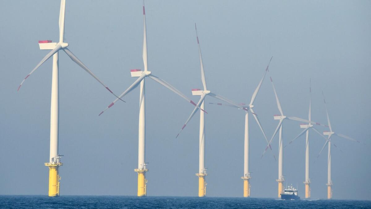 A service vessel passes by the turbines of an offshore wind farm in Germany. Renewable energy sources account for 36% of Germany's power mix.