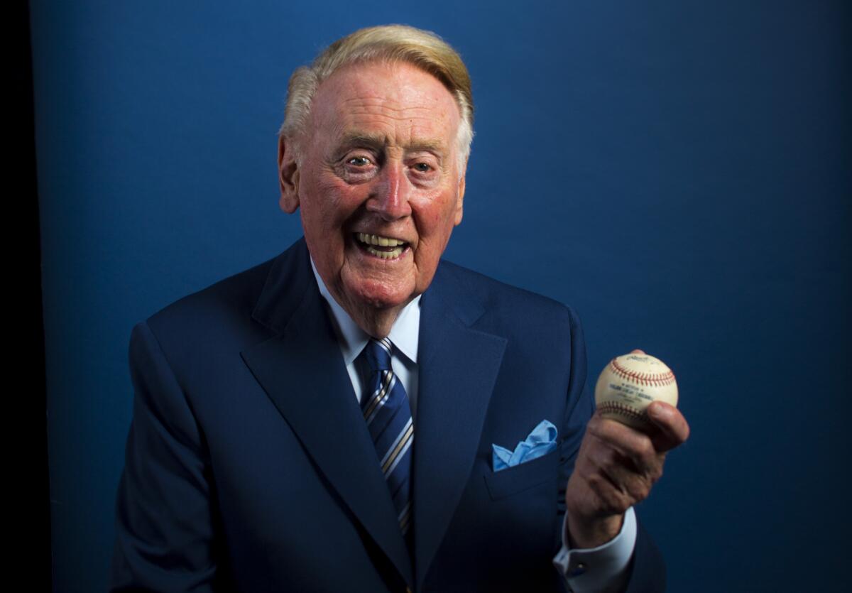 Dodgers announcer Vin Scully poses for a photograph holding a baseball.
