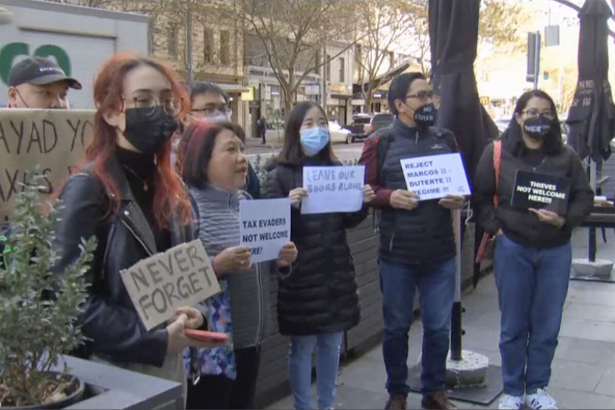 In this image made from video, members of Australia’s Filipino community protest outside an apartment, Tuesday, May 17, 2022, in Melbourne, Australia, where the Philippines' presumptive next president, Ferdinand Marcos Jr., was reportedly visiting his son. (Australian Broadcasting Corp. via AP)