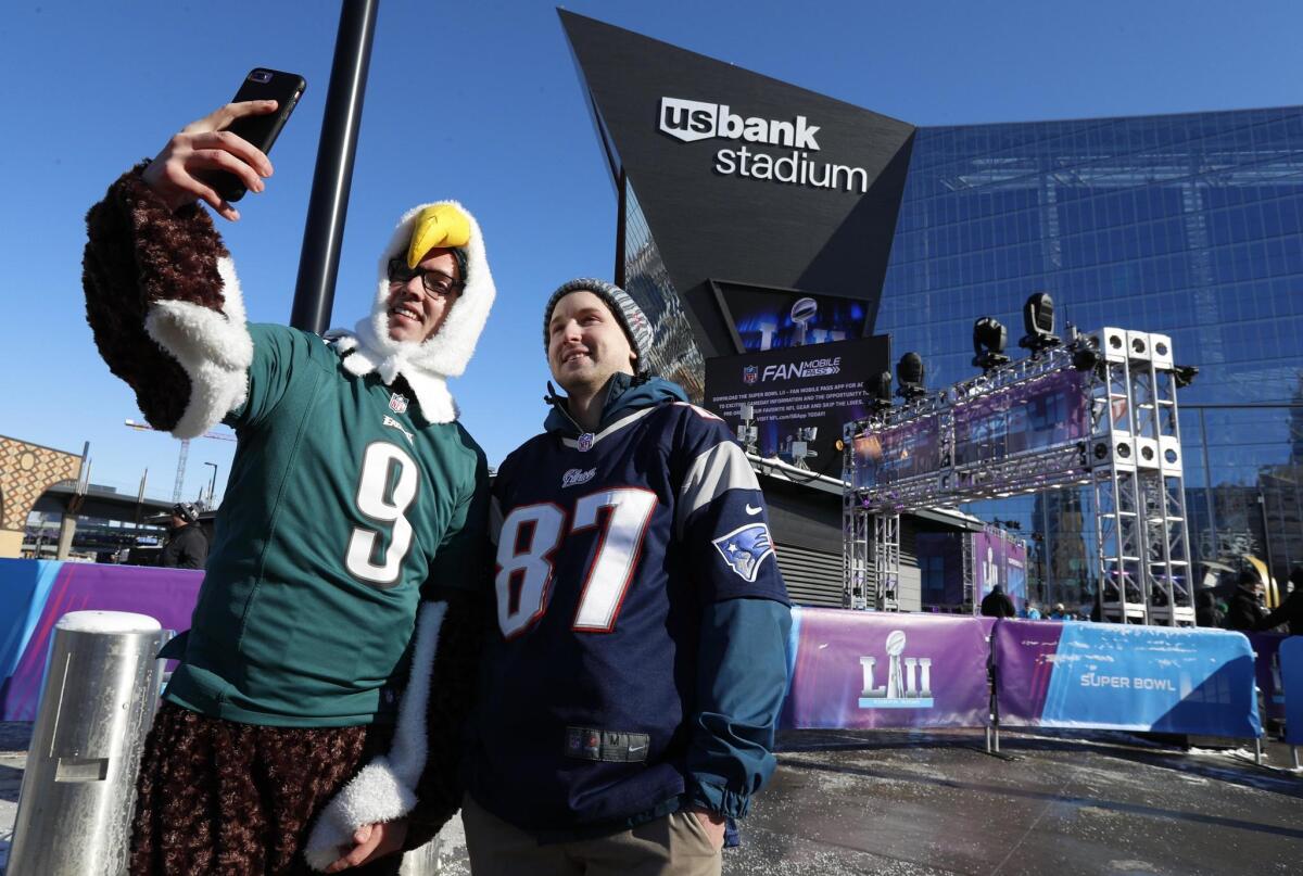 STX04. Minneapolis (United States), 04/02/2018.- A Patriots and an Eagles fan pause for a selfie in subfreezing temperatures prior to Super Bowl LII at US Bank Stadium in Minneapolis, Minnesota, USA, on 04 February 2018. The NFC Champions Philadelphia Eagles play the AFC Champions New England Patriots in the National Football League's annual championship game.