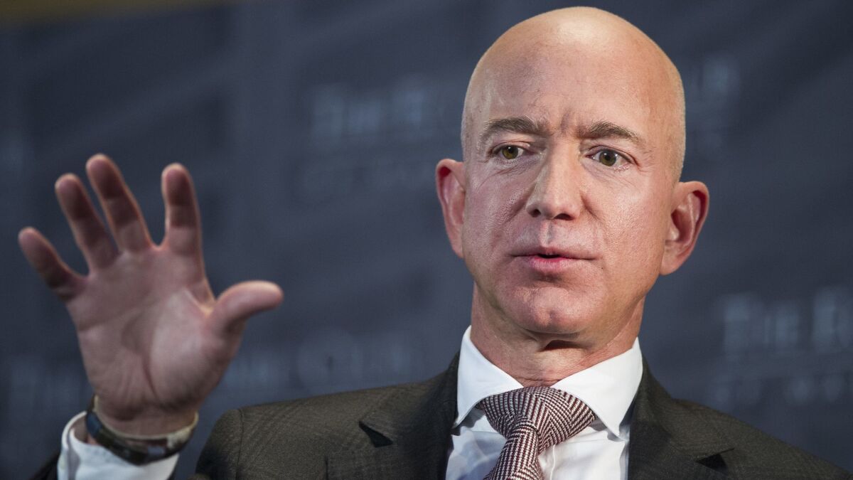 Amazon CEO Jeff Bezos accused the National Enquirer of threatening to publish revealing photos of him unless he backed off an investigation of the magazine.