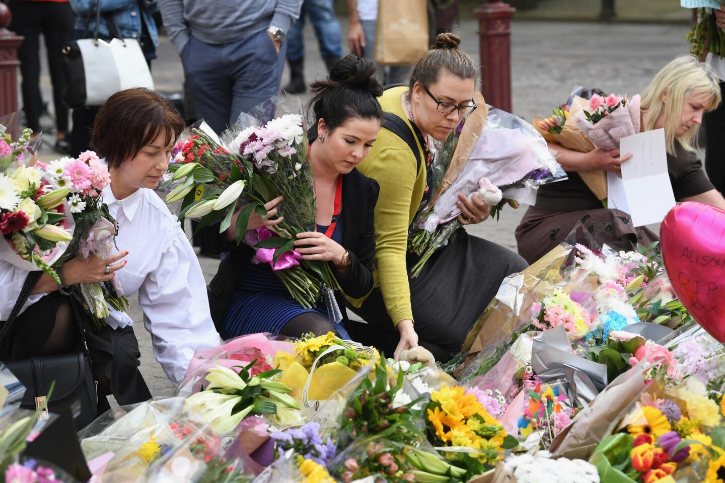 Manchester City Council workers move the floral tributes from Albert Square to St. Ann's Square on May 24, 2017, in Manchester, England.