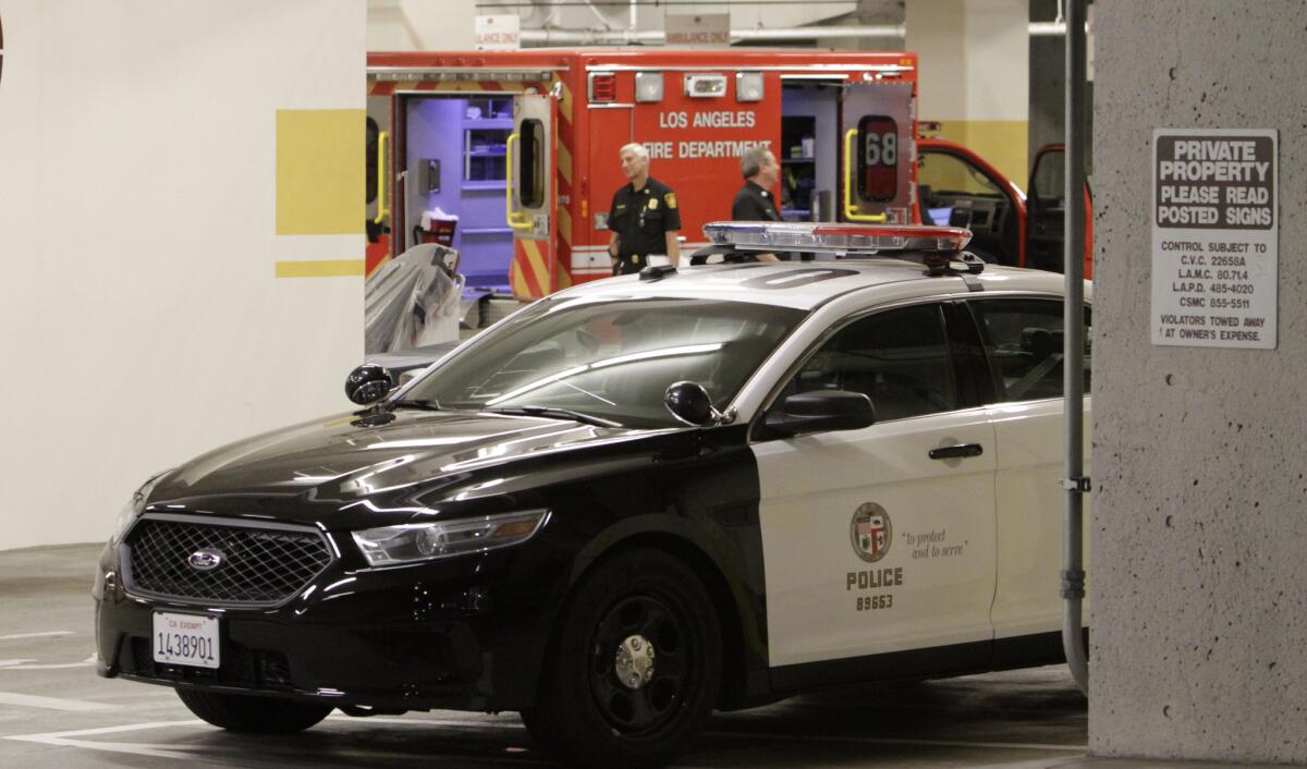 An ambulance and LAPD patrol car are shown at the emergency entrance at Cedars-Sinai Medical Center, where the wounded officer was taken.