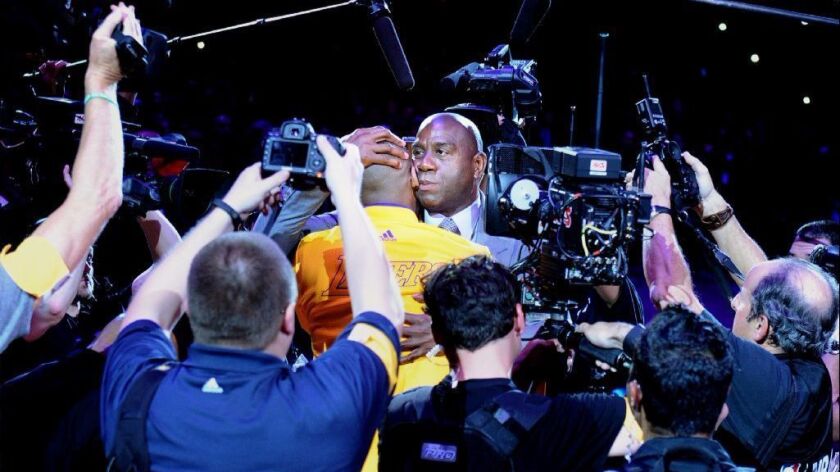 Magic Johnson hugs Kobe Bryant after he scored 60 points in his farewell game.