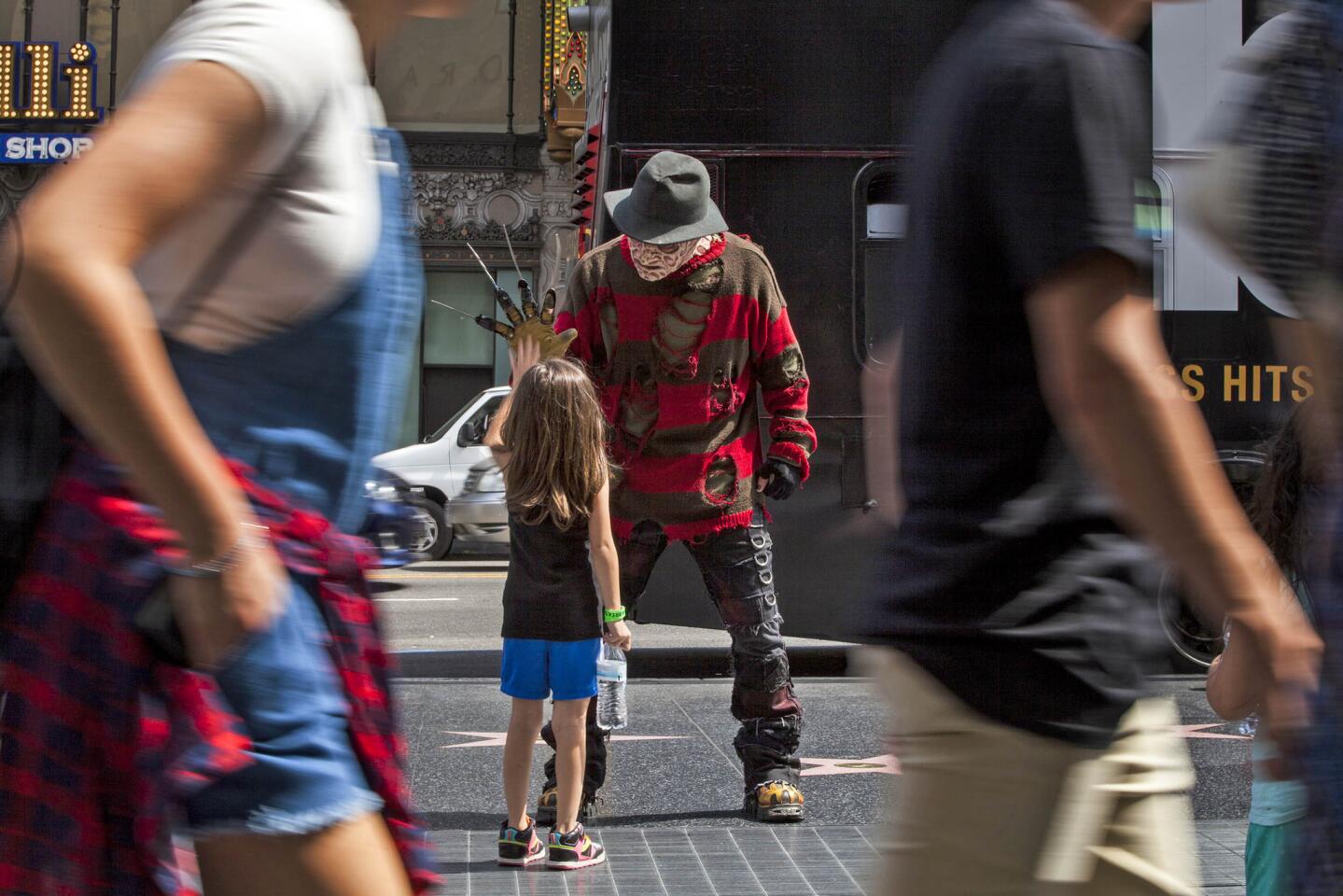 A Freddy Krueger performer greets 7-year-old Zoey Delao of El Paso, Texas, on Hollywood Boulevard during her vacation with her family.
