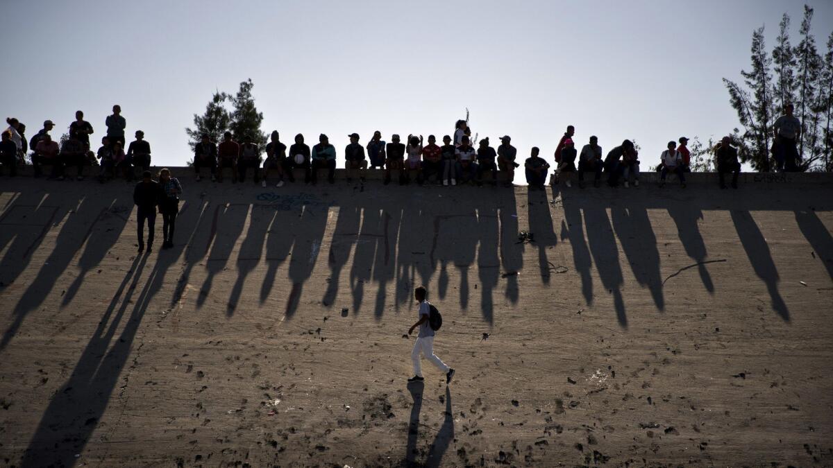 Migrants near the Chaparral border crossing watch clashes with U.S. border agents, seen from Tijuana, Mexico, on Nov. 25, 2018.