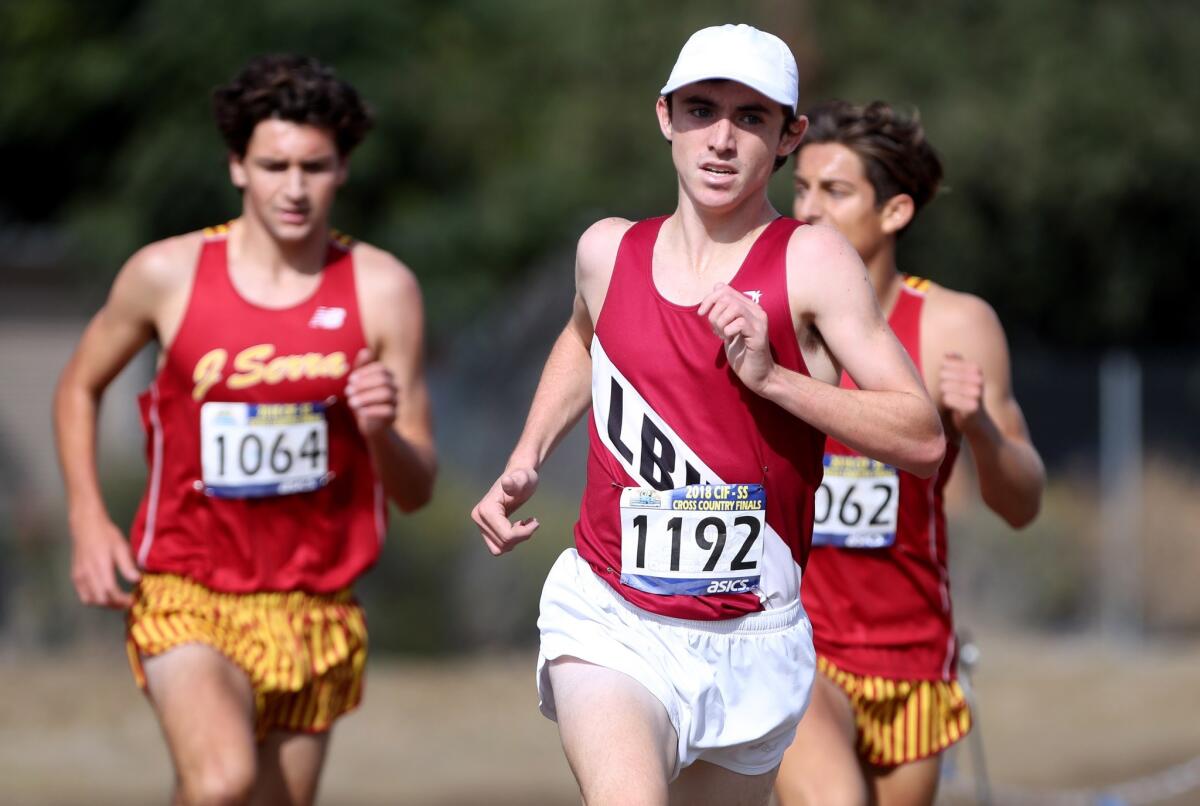 Laguna Beach High's Ryan Smithers surpasses two JSerra runners to win the CIF Southern Section Division 4 race at the Riverside City Cross-Country Course on Nov. 17, 2018.