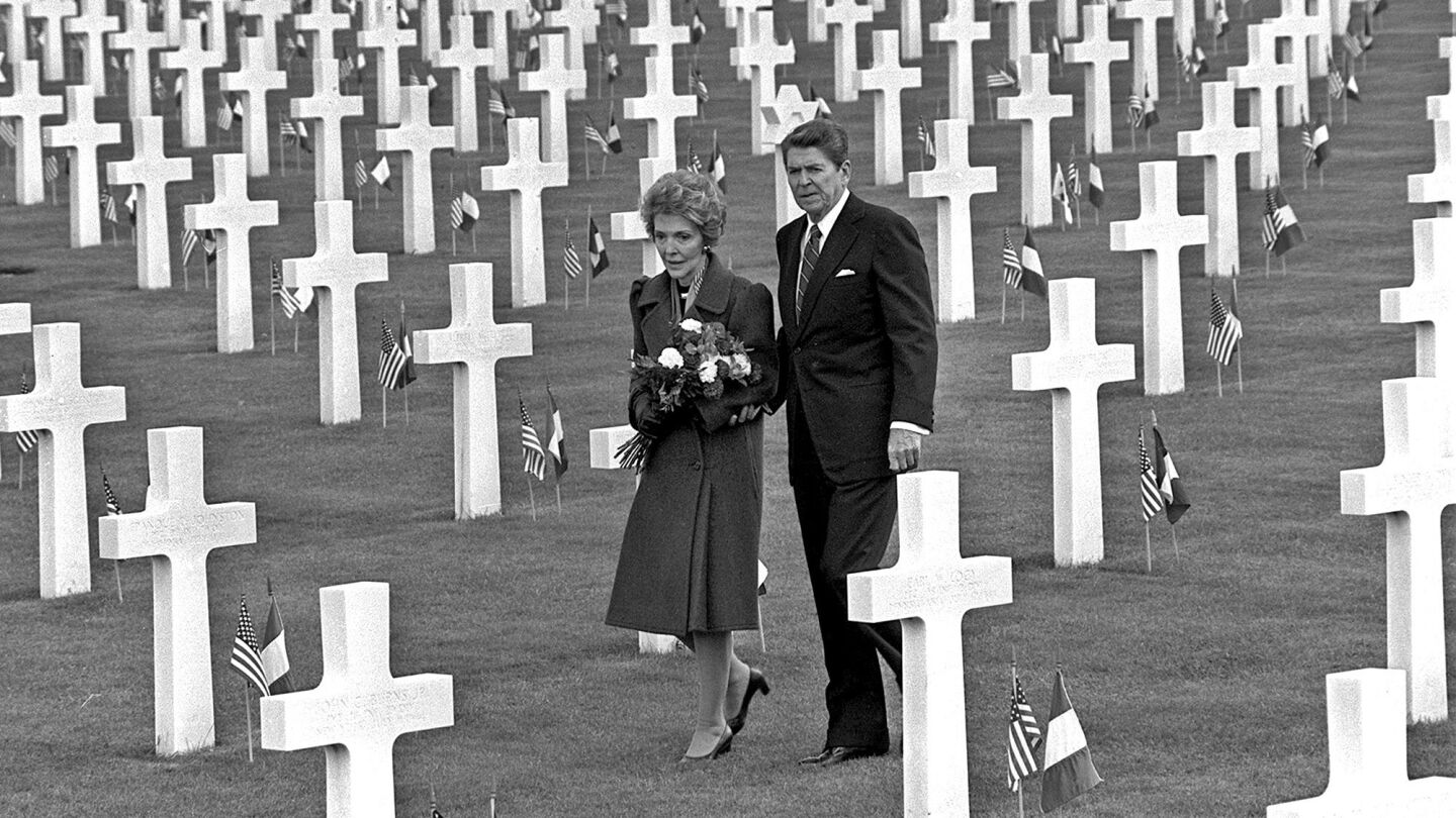 The Reagans walk through Normandy American Cemetery above Omaha Beach in northern France on June 6, 1984, the 40th anniversary of the D-day invasion.