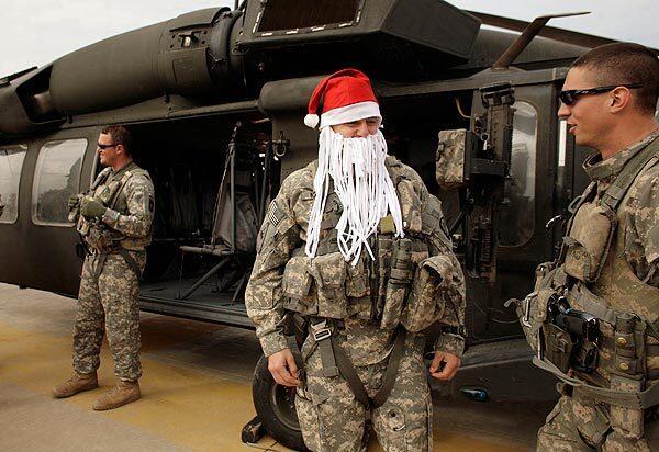 After flying in a Blackhawk helicopter, U.S. Army Chief Warrant Officer Derrick Nunley, 27, from De Soto, Kan., celebrates Christmas by wearing a Santa Claus hat and a beard made out of a shredded T-shirt at Camp Victory, the U.S. military headquarters on the western edge of Baghdad.