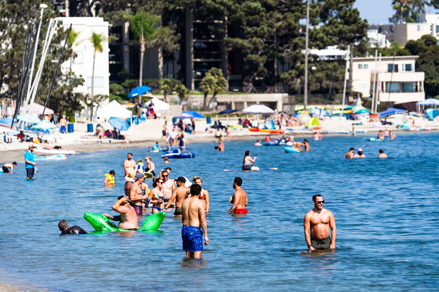 Beach-goers cool off in the waters of Sail Bay.
