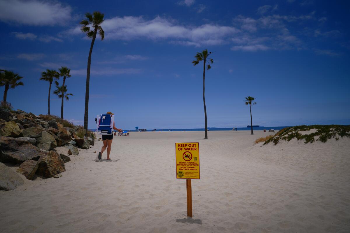 A sign warns beachgoers of a closure at a Coronado shoreline